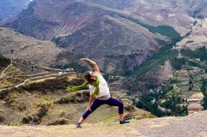 Woman doing a yoga pose on top of a mountain